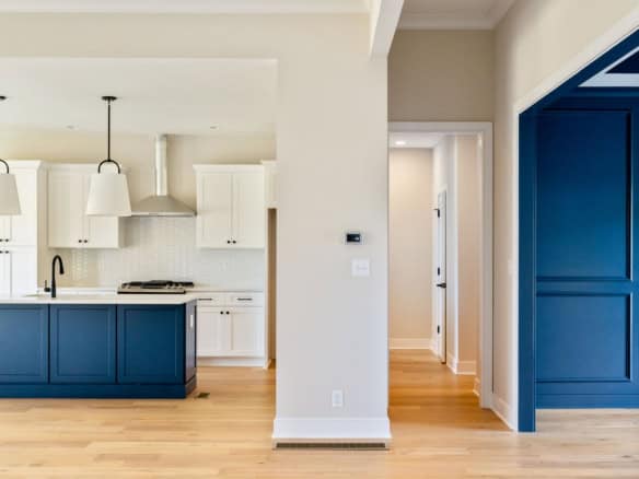 Blue and white kitchen with island and pendant lighting.