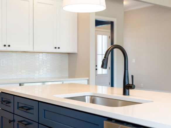 Contemporary kitchen featuring blue cabinets, white countertops, and a black faucet.