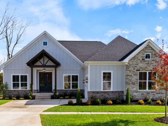 Beautiful modern farmhouse with white siding and stone accents.