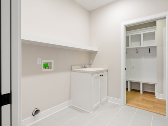 Laundry room with utility sink and storage closet.