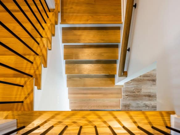 Elegant wooden staircase with black metal railings in a contemporary home.
