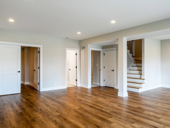 Interior view of a spacious, newly built home with hardwood floors and white walls.