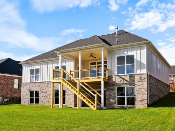 Newly built house with a spacious backyard and a wooden deck.
