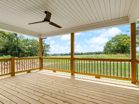 Wooden porch with railing overlooking lush green fields and trees at 3236 Catalpa Farms Dr.