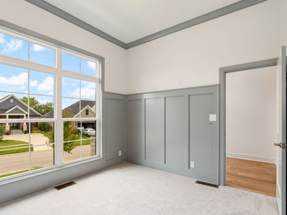 Interior view of a newly built home with large windows and modern gray wall paneling.
