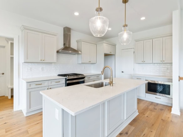 White kitchen with island and gold fixtures at 3236 Catalpa Farms Dr.