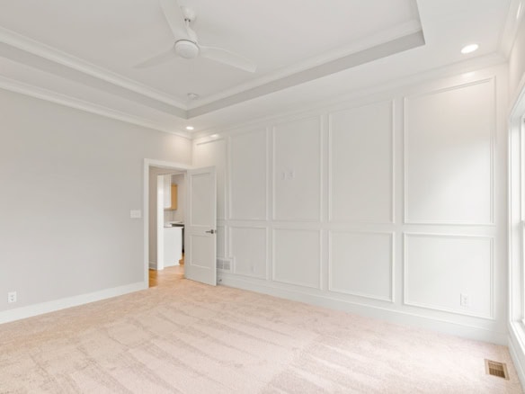 Interior view of a spacious, newly renovated room with white walls and elegant wall paneling.