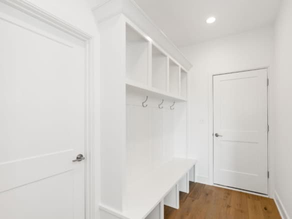 Mudroom with white cabinetry, hooks, and bench at 3236 Catalpa Farms Dr.
