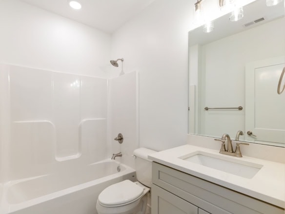 Bright, clean bathroom with bathtub and vanity in a new home.