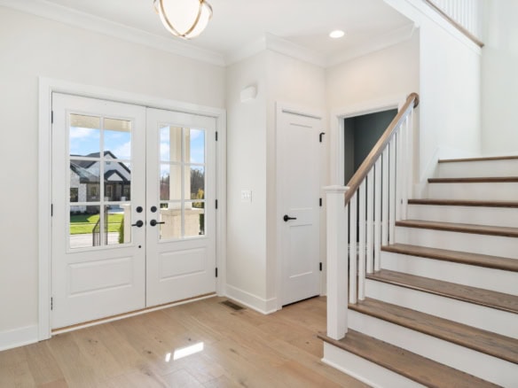 Entryway with white doors, staircase, and natural light at 3320 Catalpa Farms Dr.