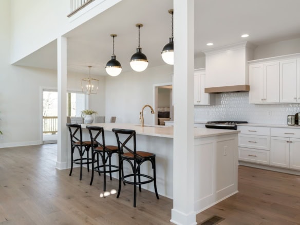 Modern kitchen with white cabinets and open layout.