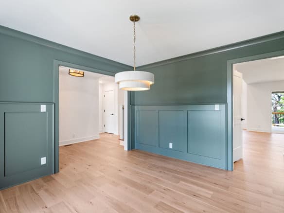 Interior view of a newly constructed home with stylish green wall paneling and natural light.