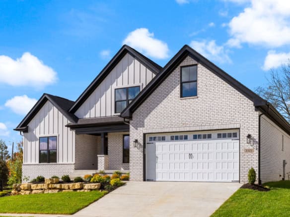 Beautiful new construction home featuring white brick and siding, with a spacious garage and landsca.