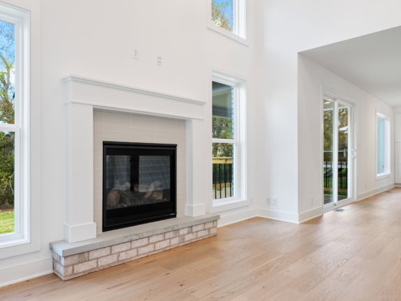 Bright living room featuring a modern fireplace and large windows.
