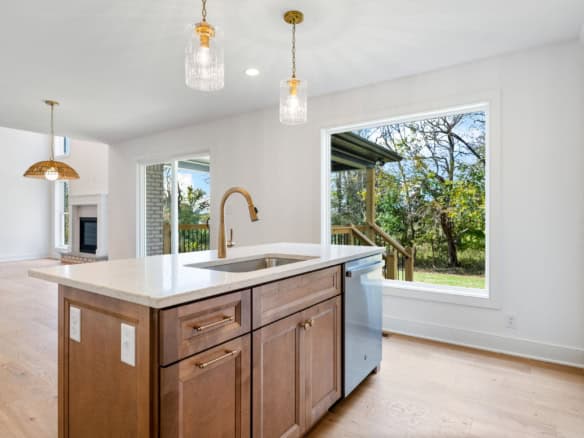 Bright, open-concept kitchen featuring a central island, pendant lighting, and scenic outdoor views.