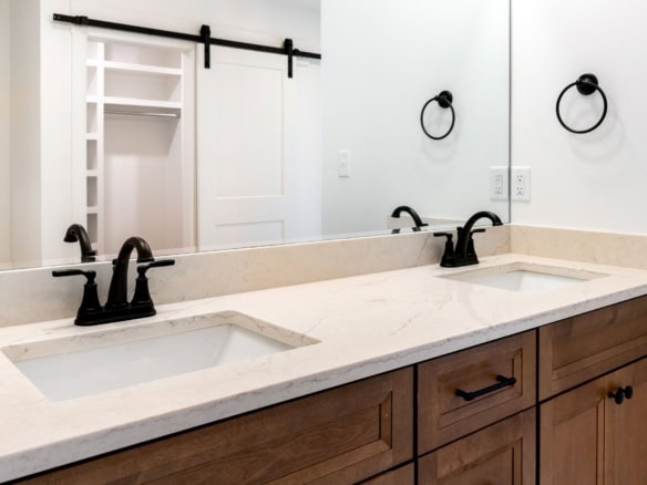 Double sink bathroom vanity with elegant black fixtures and a spacious marble countertop.