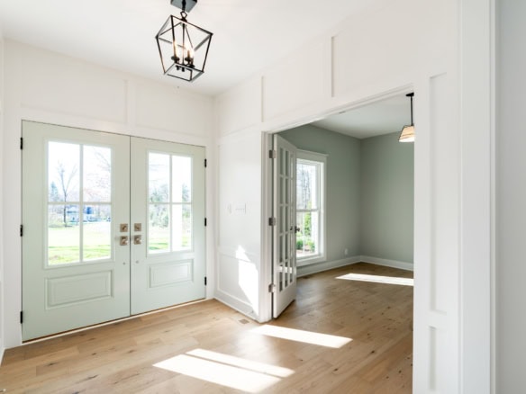 Bright entryway featuring double glass doors and natural light.