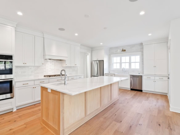 Kitchen with white cabinets, island, and stainless steel appliances.