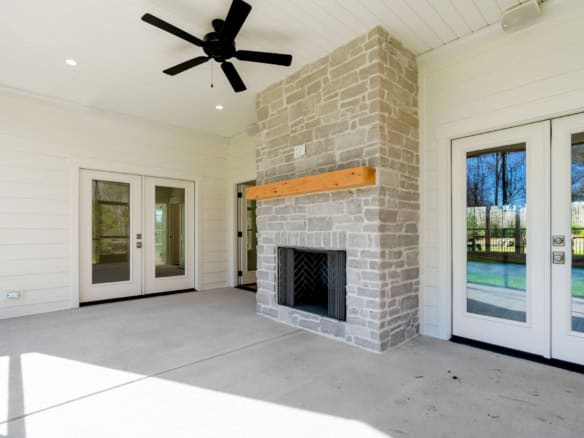 Beautiful outdoor living space with a stone fireplace and modern doors.