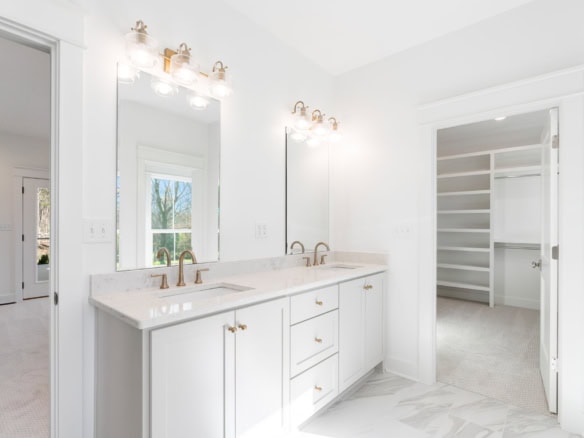 Bathroom vanity with double sinks and large mirror in a bright, modern bathroom.