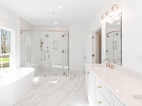 Modern bathroom featuring a spacious walk-in shower with glass doors and elegant fixtures.