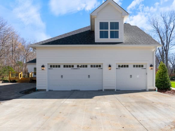 Garage with three doors and a dormer window at 6037 Cherry Lane.
