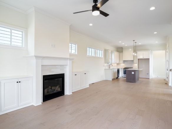 Spacious living area with fireplace and large windows in a new home at 6111 Passionflower Dr.
