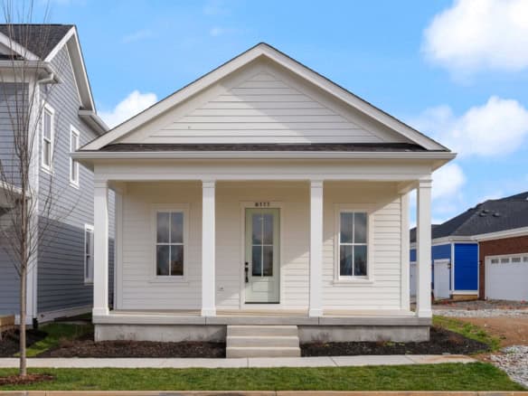 Newly built house at 6111 Passionflower Dr with a classic porch and white siding.