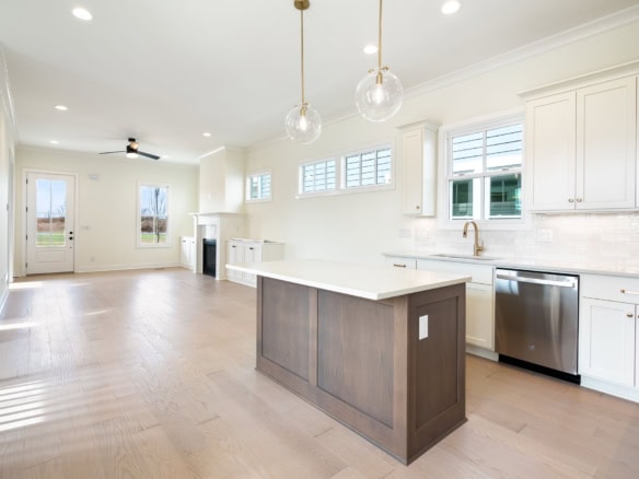Modern kitchen with white cabinets, island, and stainless steel appliances.