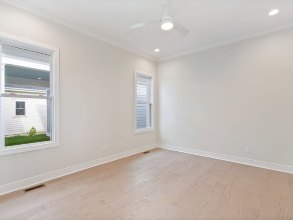Interior view of a bright, spacious room at 6111 Passionflower Dr with white walls and large windows.