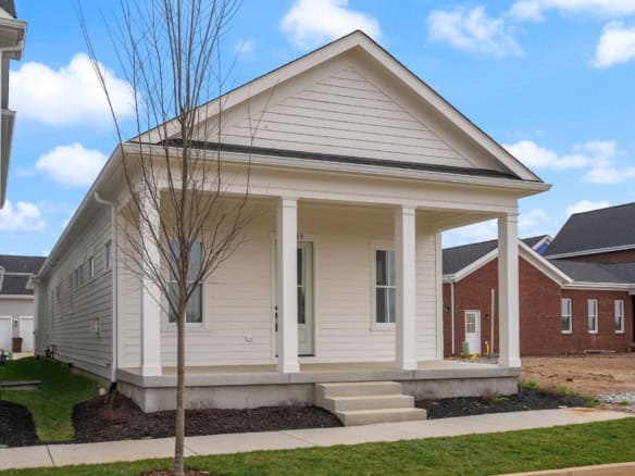 Modern new home with welcoming front porch and clean white siding.