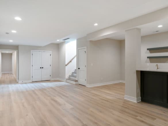Bright and spacious basement with light wood flooring and neutral walls at 6111 Passionflower Dr.