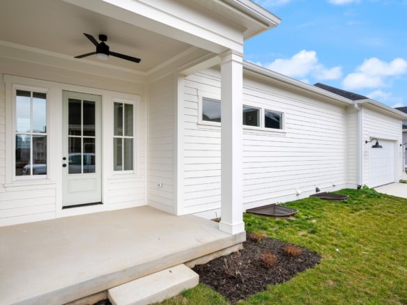 Modern white house exterior with a covered porch and black ceiling fan at 6111 Passionflower Dr.