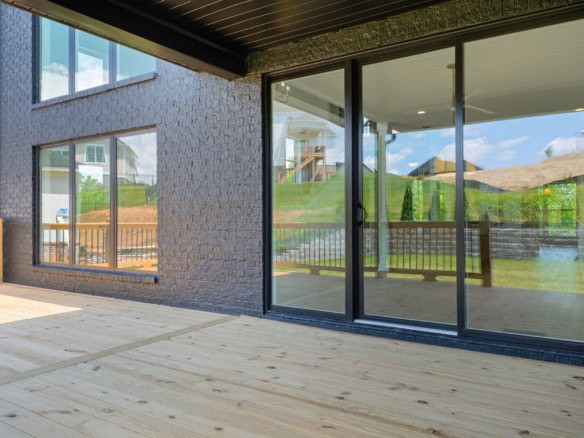 Modern home extension with large glass sliding doors and a spacious deck.