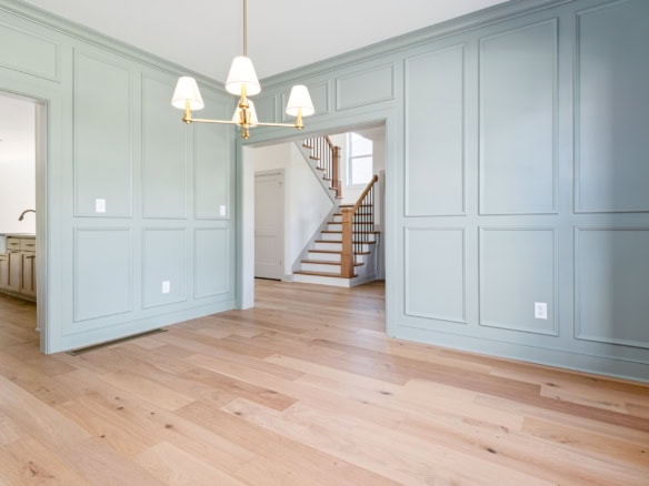 Beautiful light blue wall paneling with a chandelier in a spacious living area.
