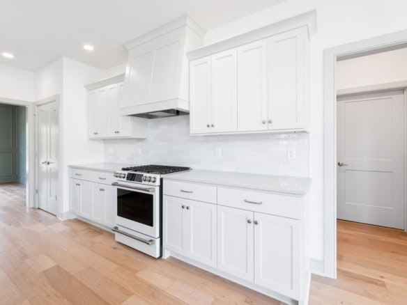 White kitchen cabinets and appliances in a newly renovated home.