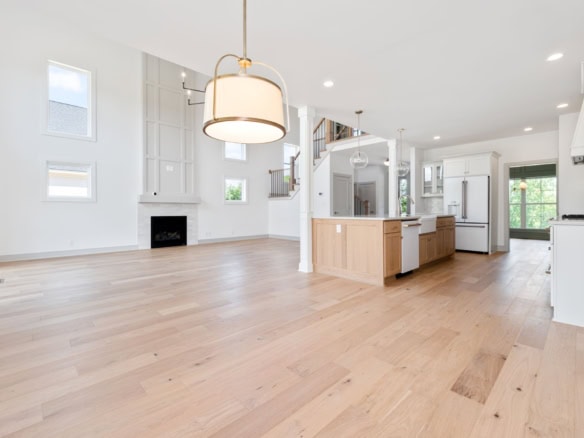 Spacious interior with white walls, large windows, and hardwood flooring in a contemporary home.