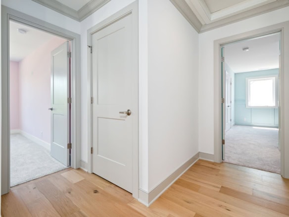 Bright hallway with white walls and hardwood floors in a residential home.