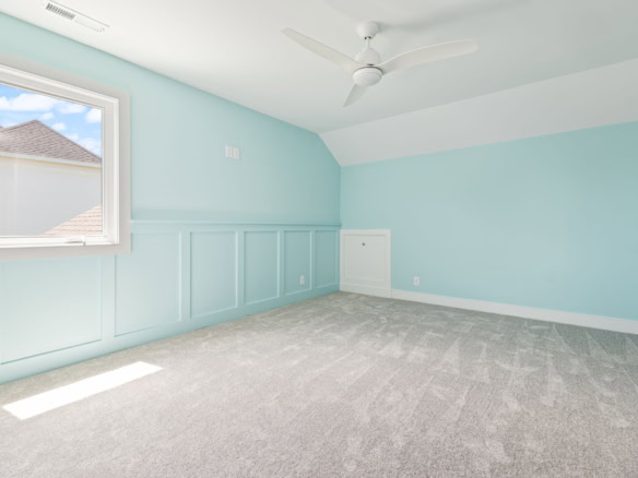 Bright, airy room with light blue walls and large window at 6207 Brentwood Dr.