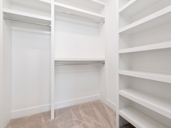 Walk-in closet featuring ample storage with hanging rods and shelves for organized clothing and acce.