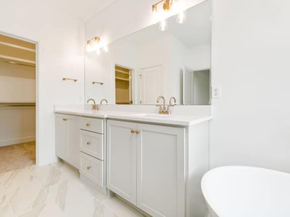 Bathroom vanity with dual sinks and ample storage in a bright, contemporary space.