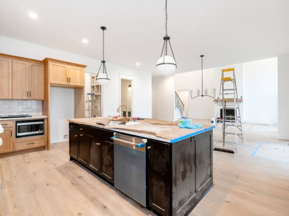 Kitchen in progress with island, cabinets, and lighting fixtures at 6307 Brentwood Dr.