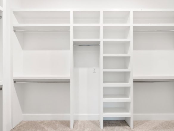 Custom white closet storage with shelves and hanging space.