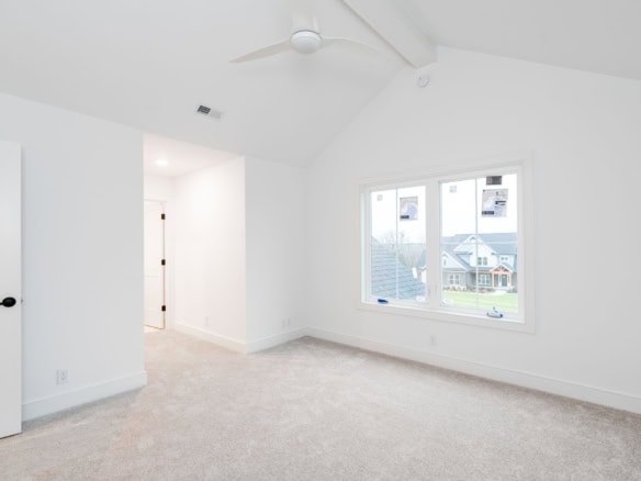 Bright, spacious interior room with large windows and modern ceiling fan.