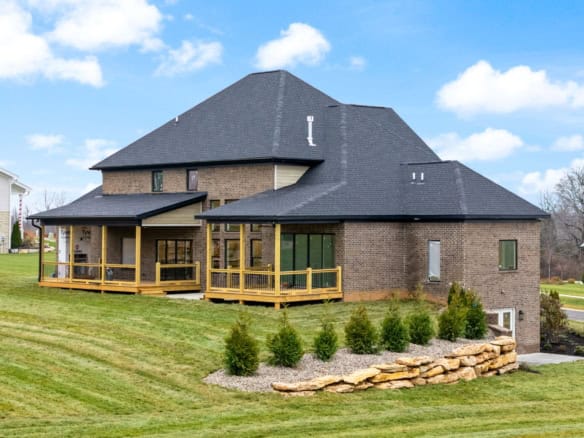 Beautiful brick house with a spacious wraparound porch and landscaped yard.