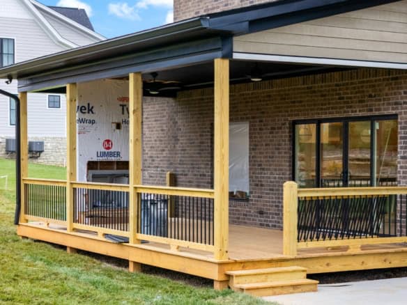 New wooden deck with railing and steps built on brick house at 6307 Brentwood Dr.