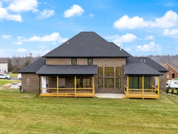 New construction brick house with large backyard and two decks.