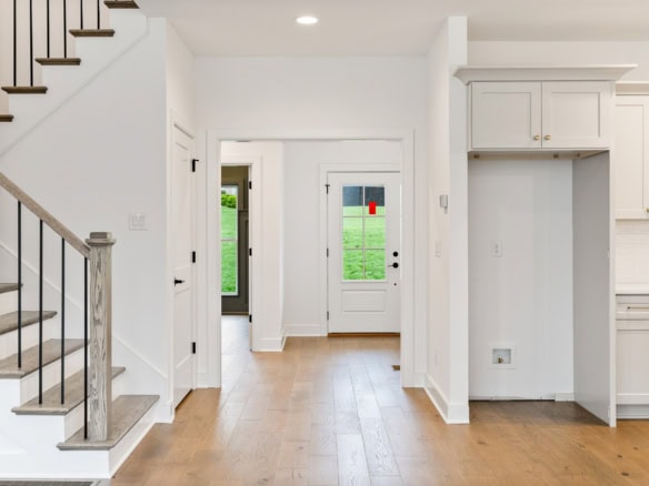 Bright, open-concept kitchen and entryway in a newly built house.