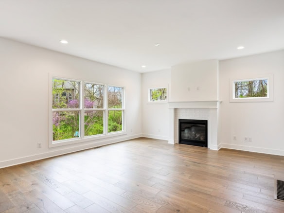 Bright living room with fireplace and expansive window views.