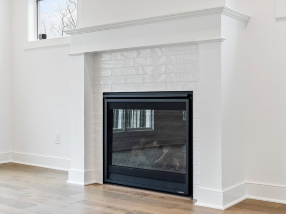 Modern fireplace with white brick mantel in a bright living room.